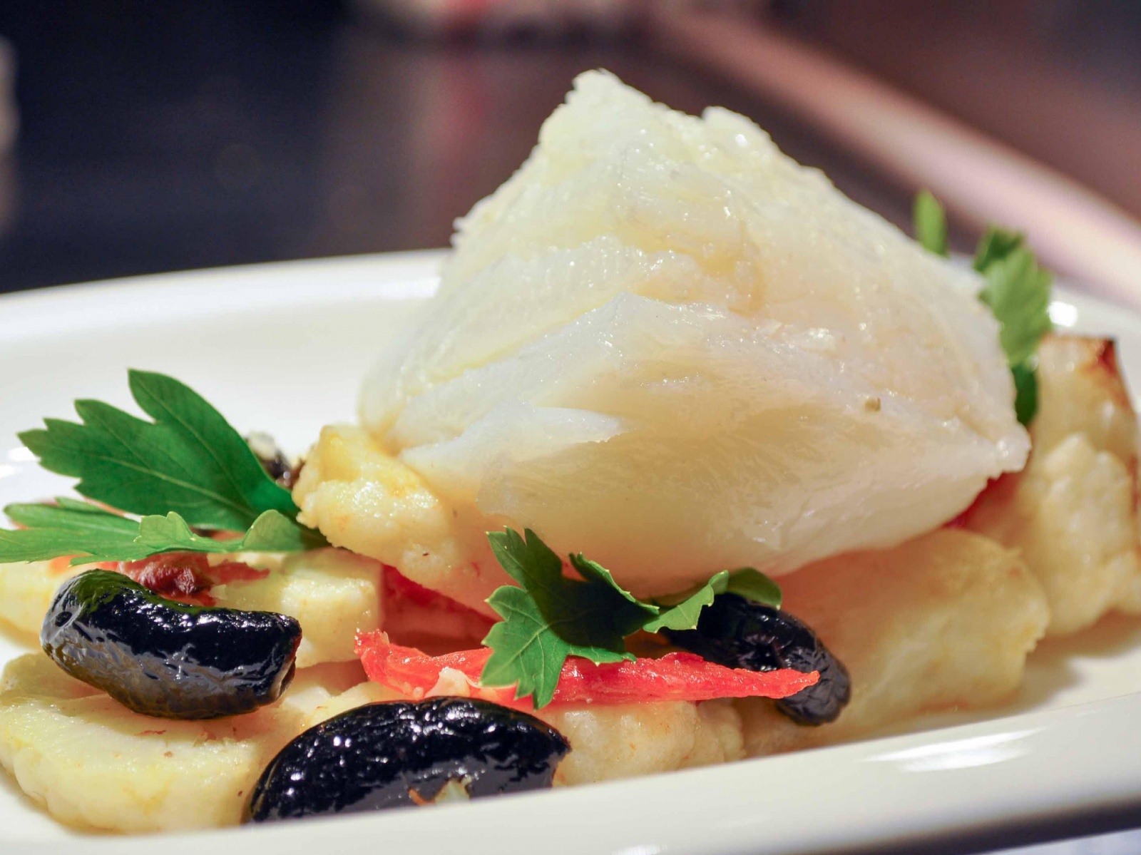 Baccalà su letto di cavolfiori, olive al forno e pomodori confit