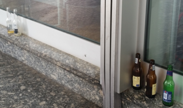 Bottiglie vuote sotto i portici di via Marconi 