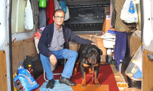 Vincenzo Fedele con il suo cane all’interno del furgone dove ora abita
