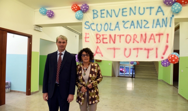 Davide Galimberti e Rossella Dimaggio davanti allo striscione di benvenuto che i genitori della Don Bosco hanno  preparato per  bambini e insegnanti della Canziani (Blitz)
