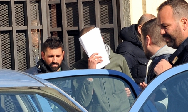 Abderrahmane Khachia, (anche a lato), arrestato dagli agenti della Digos mentre viene portato in carcere (Archivio)