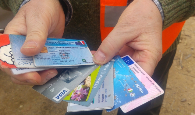 Le carte di credito e documenti ritrovati nel bosco. sopra, il gruppo dei volontari (Blitz)