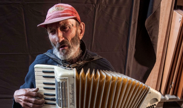 Enrico Rocca suona la fisarmonica e promette di svuotare la sua casa da tutta la mercanzia accumulata in tanti anni (foto Blitz di Davide Caforio)