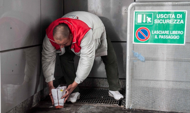 Un compagno di sventura e connazionale del tunisino morto lascia dei fiori nel giaciglio che per mesi ha visto il 41enne trascorrere le sue giornate (foto Blitz di Davide Caforio)