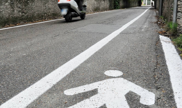 Lungo la strada che sale da viale Aguggiari verso Ville Ponti è stata rifatta la segnaletica orizzontale (foto Blitz)