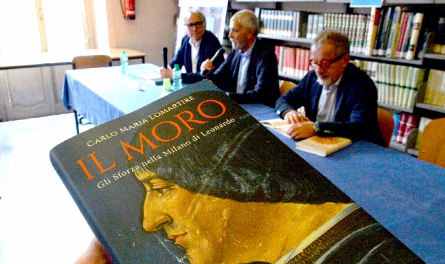 La presentazione del libro alla biblioteca civica: in primo piano il libro, in alto da sinistra Maurizio Lucchi, Lomartire e Roberto Maroni (Blitz)