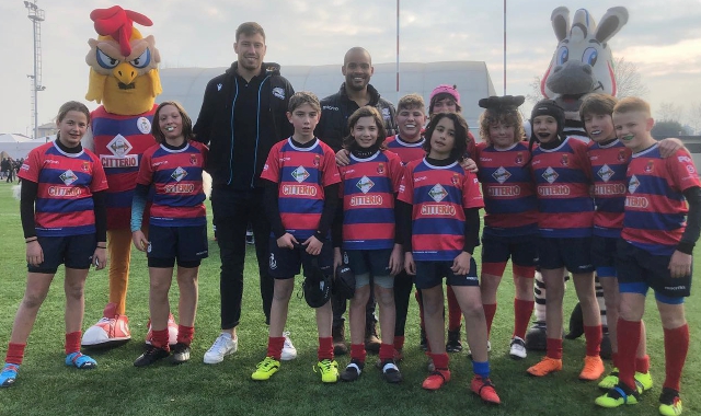 Lorenzo Masselli e Maxime Mbanda, in posa con i piccoli giocatori rossoblù (foto Rugby Parabiago)
