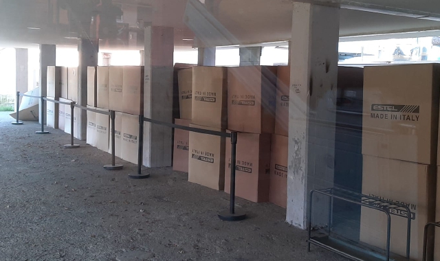 I banchi a rotelle inscatolati e depositati sotto il portico della scuola media (Foto Redazione)