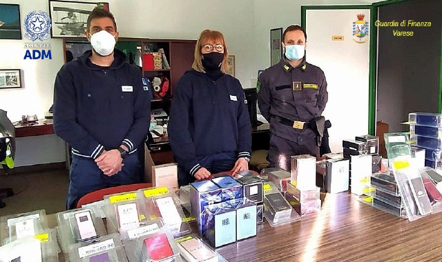 Le forze dell’ordine coi profumi sequestrati (foto Redazione)