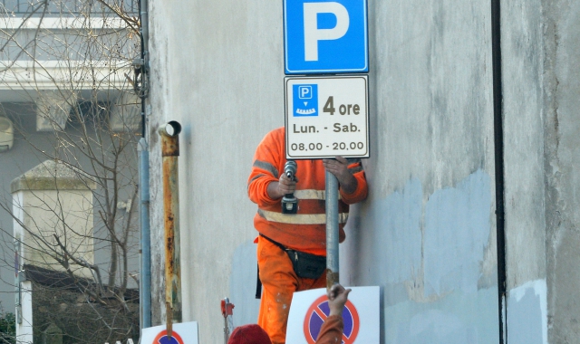 La sistemazione dei nuovi cartelli della sosta (foto Blitz)