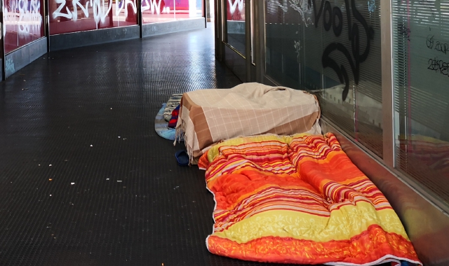 Nel passaggio pedonale tra viale Milano e via Orrigoni hanno trovato posto alcuni senzatetto, che hanno allestito  giacigli sotto il portico (foto Blitz)