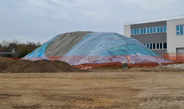 In alto la collina di amianto coperta da pesanti teli accanto agli scavi del sottopasso. Spesso c’è chi si disfa dell’eternit nei boschi 