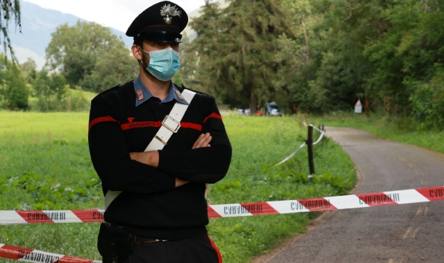 Un agente dei carabinieri nell'area dove è stato trovato il cadavere della donna (Ansa)