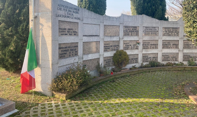La bandiera raccolta da terra e appoggiata al monumento (foto Blitz)