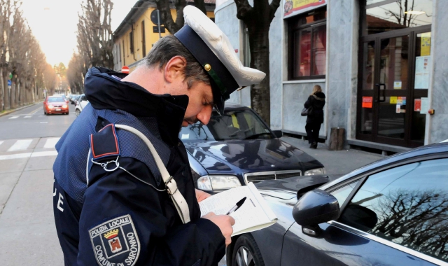 Un agente della polizia locale di Saronno mentre stacca una multa (Blitz)