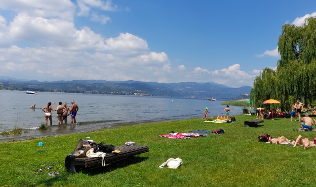 Primi tuffi, seppur timidi per il freddo delle acque del Lago Maggiore, alla spiaggia di Lisanza, a due settimane dal naufragio della barca travolta