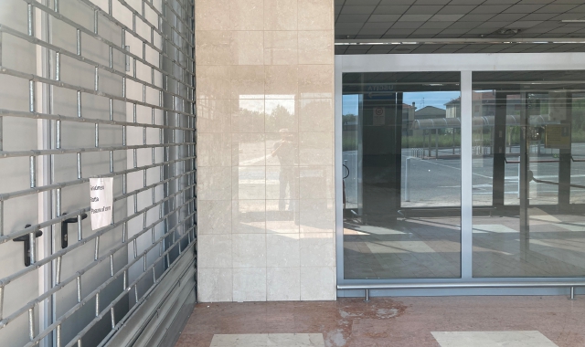 Due immagini del centro commerciale Ticino, oggi chiuso al pubblico. Sopra l’esterno così come appare oltre la sbarra del parcheggio, sotto una veduta dell’interno