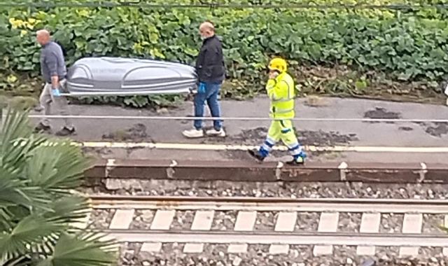 Il corpo della donna viene trasportato lontano dai binari (foto Redazione)