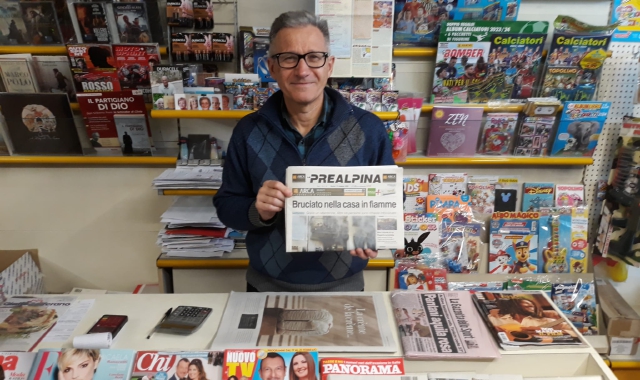 Roberto Garofalo nella sua edicola con in mano una copia della Prealpina