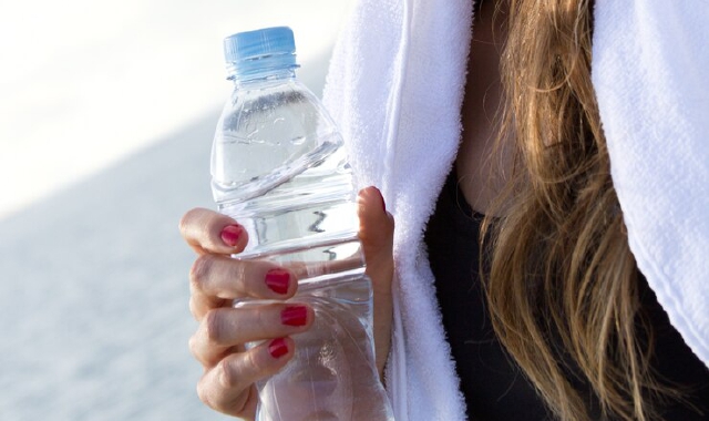 Donna che beve acqua in montagna (Foto Archivio)