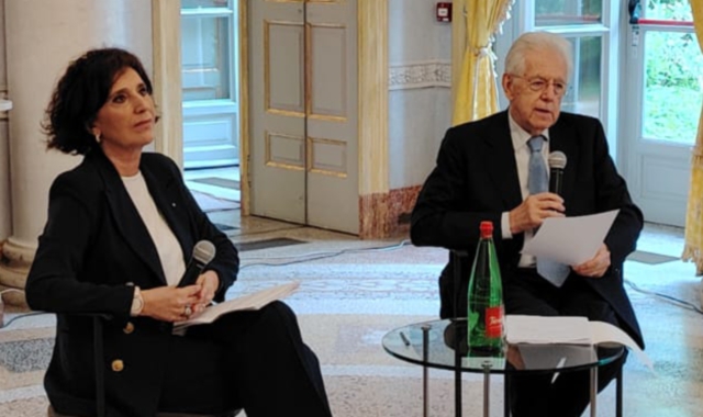 Nella foto sopra, Mario Monti intervistato da Rosi  Brandi. Qui, la firma su un gioco in cui il prof appare su una banconota