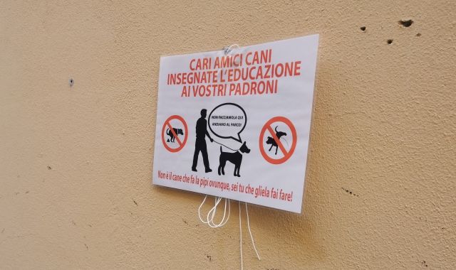 Il cartello che invita a non lasciare che i cani sporchino e a pulire 
