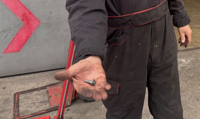 Un gommista mostra una vite che ha provocato l’ennesima foratura di uno pneumatico a Fagnano