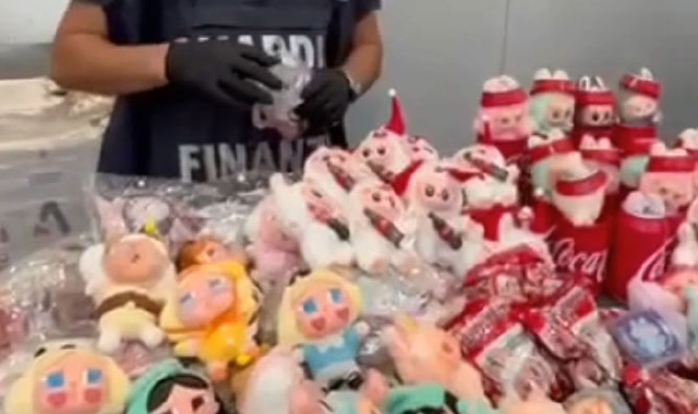 Un militare della guardia di finanza con parte dei giochi e dei pupazzi tarocchi sequestrati 